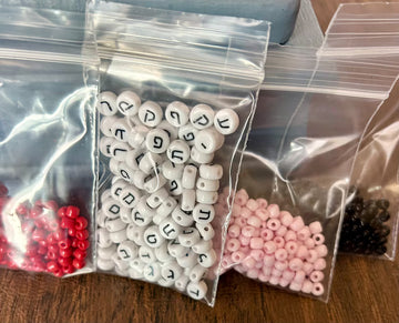 Large Hebrew letter bead bracelet making kit by Pretty Beans featuring red beads and DIY jewelry supplies.