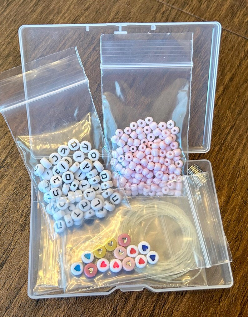 DIY Hebrew letter bracelet making kit by Pretty Beans with seed beads and silver charms for jewelry crafting.
