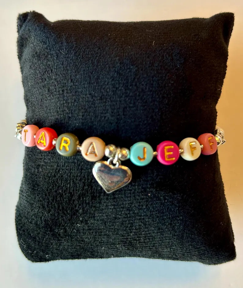 DIY jewelry kit by Pretty Beans featuring seed beads, alphabet beads, and silver-plated charms for bracelet making.