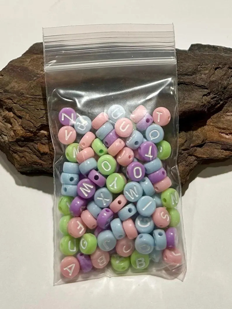 DIY jewelry kit by Pretty Beans with seed beads, alphabet beads, and silver-plated charms for bracelet making.