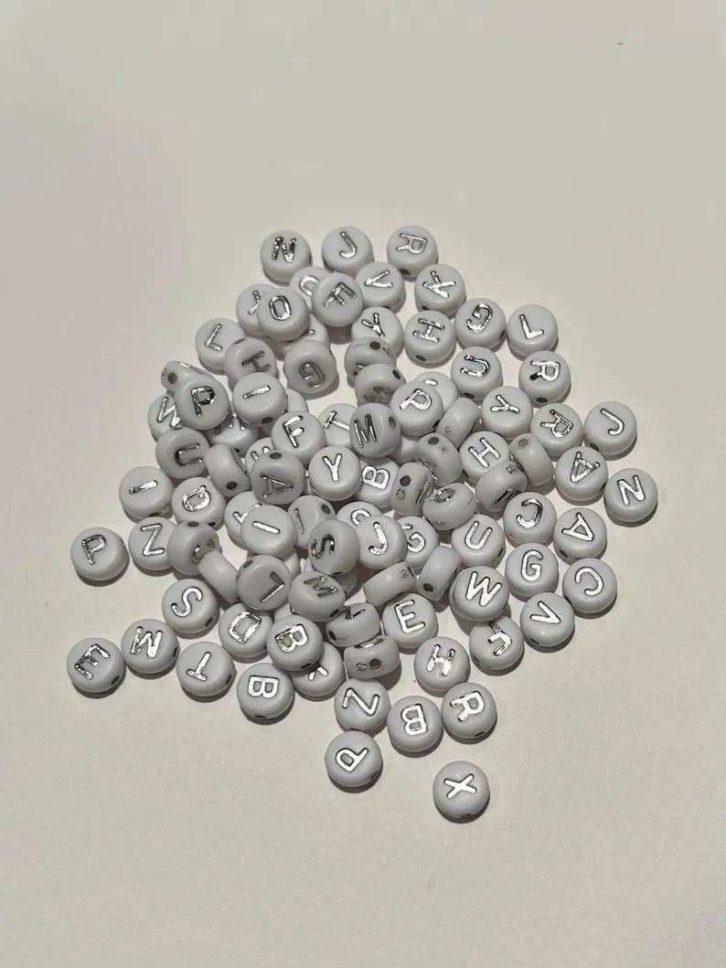 DIY jewelry kit by Pretty Beans with seed beads, letter charms, and silver charms for making mini bracelets.