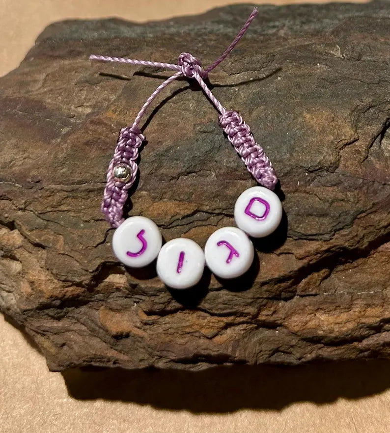 Purple Hebrew letter beads with heart spacers, tiny spacers, and silver-plated accents, perfect for jewelry-making by Pretty Beans.