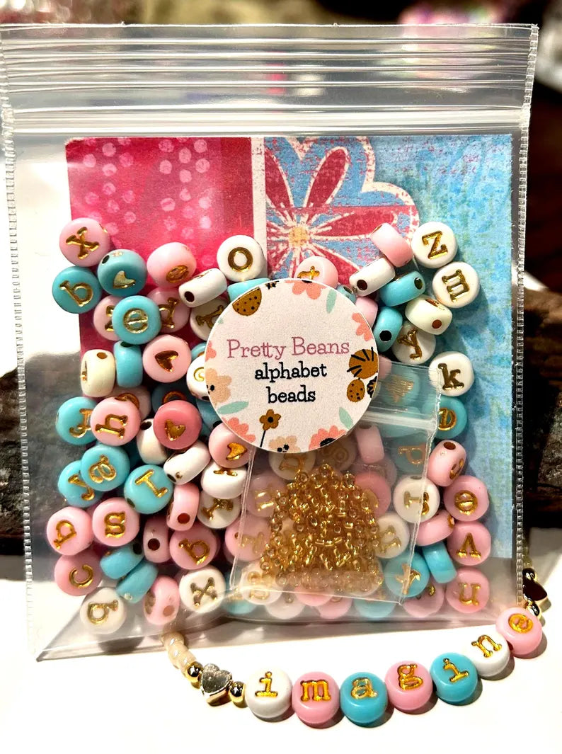Lowercase gold alphabet beads with 7mm typewriter font for jewelry making, shown in an image with beads and jewelry supplies.