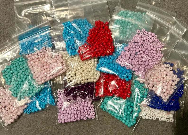 DIY jewelry kit by Pretty Beans featuring seed beads, alphabet beads, and silver plated charms for bracelet making.