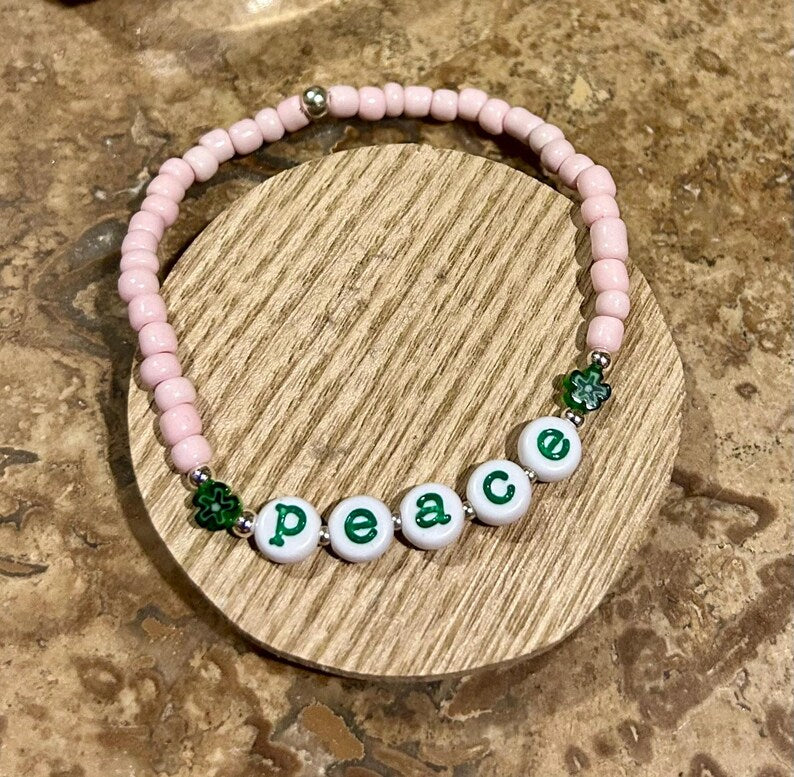 Colorful lowercase alphabet beads with typewriter font, 7mm size, from Pretty Beans, displayed in a close-up shot.