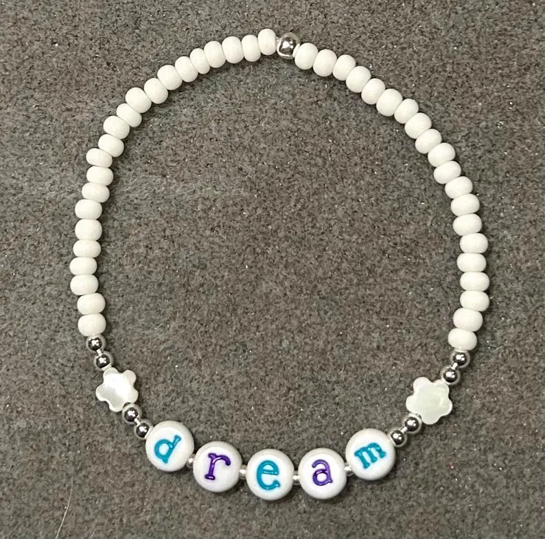 Colorful lowercase alphabet beads for jewelry making, 7mm letter beads by Pretty Beans, shown in a close-up image.