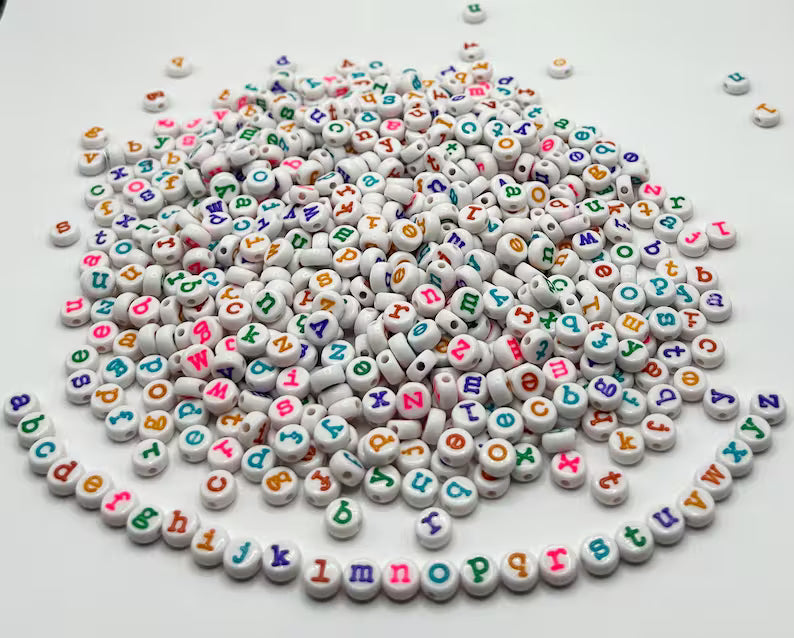 Colorful lowercase alphabet beads in typewriter font, 7mm size, arranged in a cluster showcasing vibrant, playful lettering.