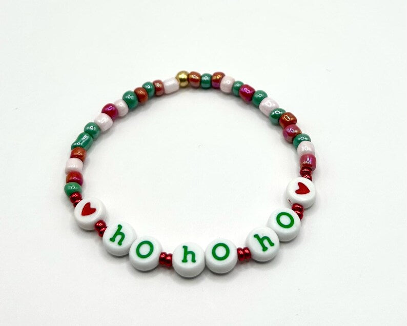 Pretty Beans DIY holiday bracelet making kit with seed beads and lowercase alphabet charms for custom jewelry crafting.