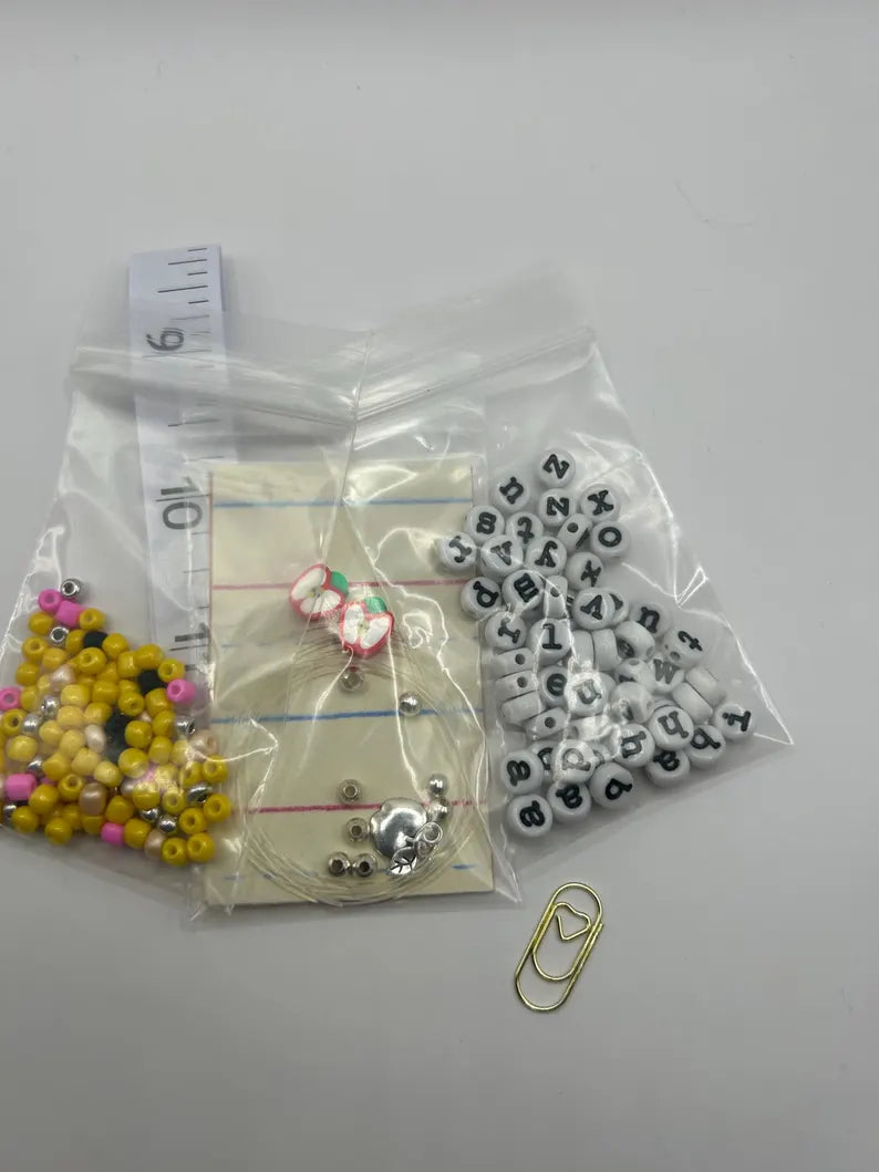 DIY teacher bracelet making kit by Pretty Beans featuring seed beads, letter beads, and apple charms for jewelry crafting.