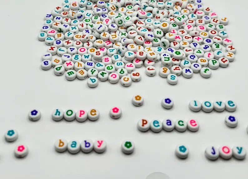 Colorful lowercase alphabet beads with 7mm size, perfect for jewelry making by Pretty Beans, shown in a close-up image.