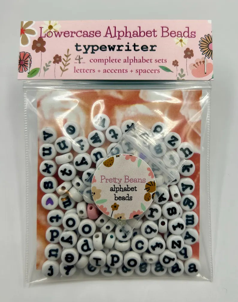 Lowercase typewriter font alphabet beads in 7mm size, featuring clear, vintage-style letter beads from Pretty Beans.