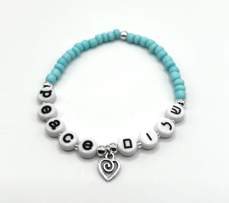 DIY Hebrew letter bracelet making kit by Pretty Beans with seed beads and silver charms for creating personalized jewelry.