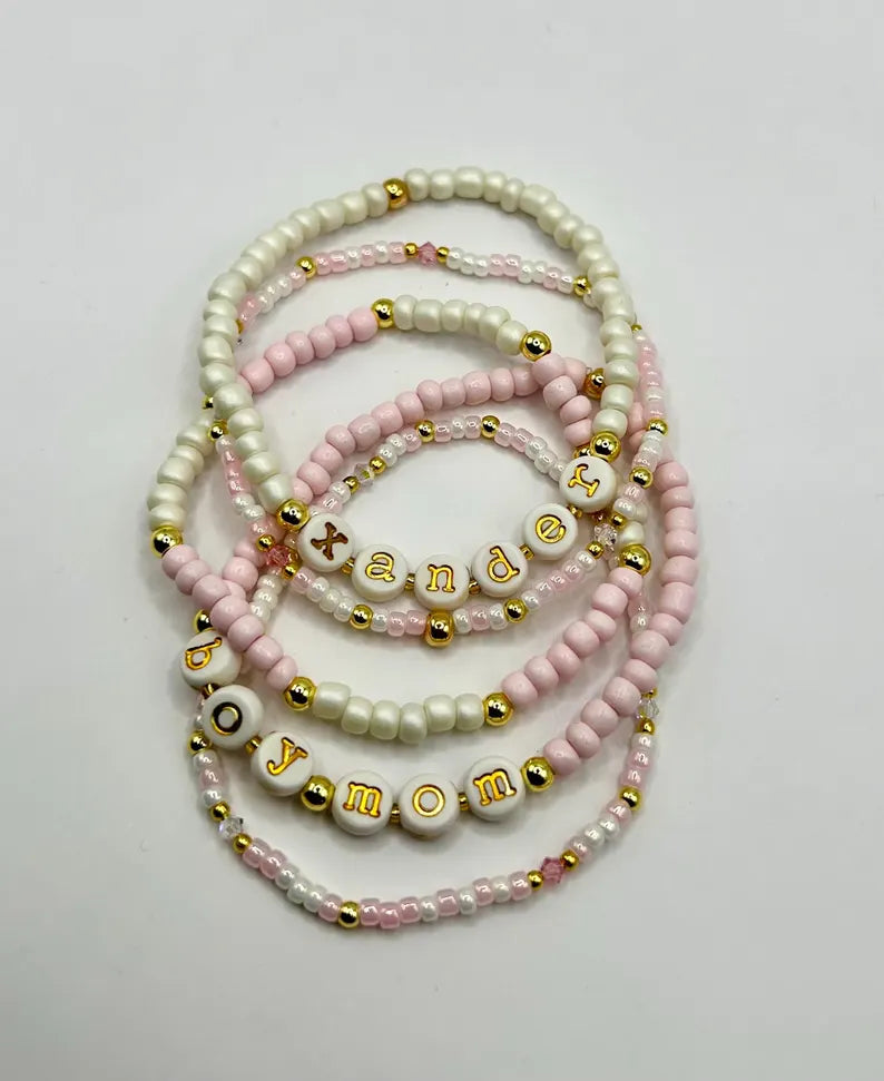 Gold lowercase alphabet beads with 7mm typewriter font, ideal for jewelry making, shown in a close-up image.