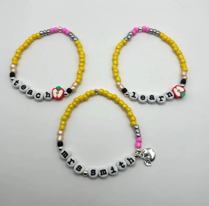 Lowercase typewriter font alphabet beads, 7mm size, in a natural wood finish, displayed in a close-up shot.