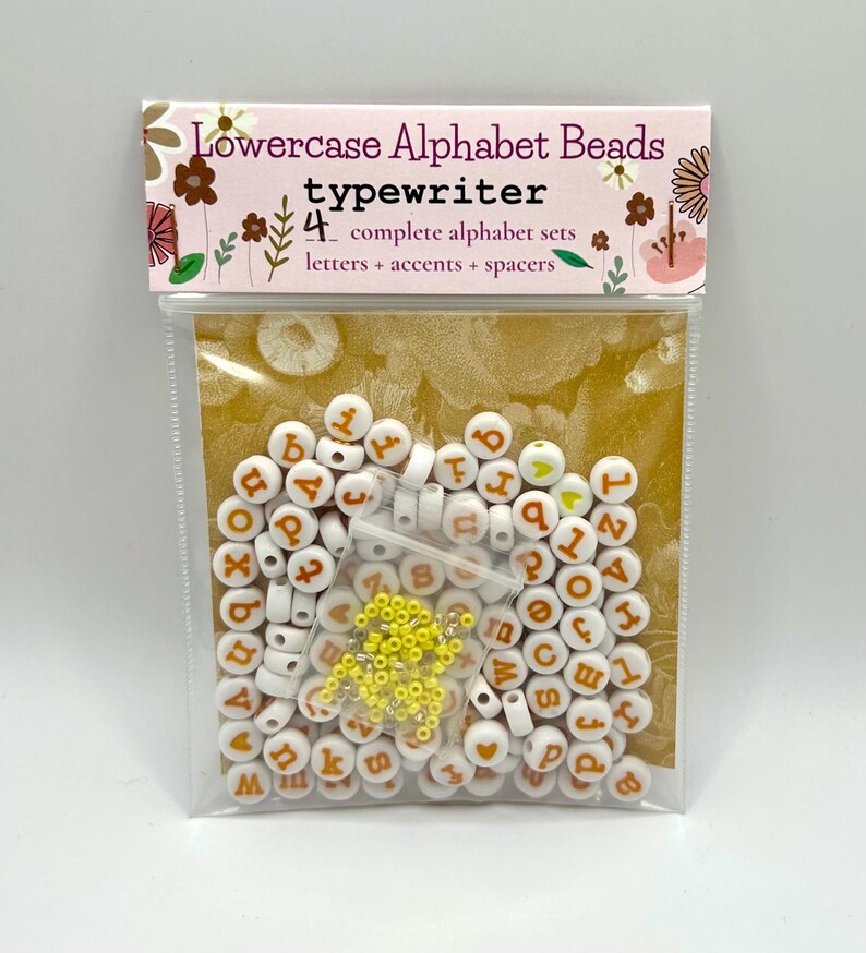 Yellow lowercase alphabet beads with 7mm typewriter font from Pretty Beans, showing close-up of individual beads on string