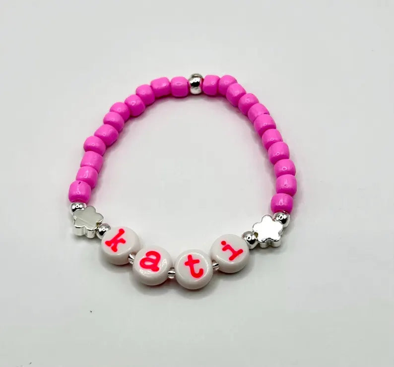 Hot pink lowercase alphabet beads in 7mm typewriter font, perfect for jewelry making, shown in a set of 120 pieces.