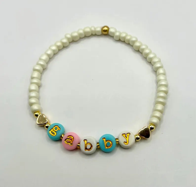 Lowercase gold alphabet beads with 7mm typewriter font for jewelry making, featuring the Pretty Beans brand.