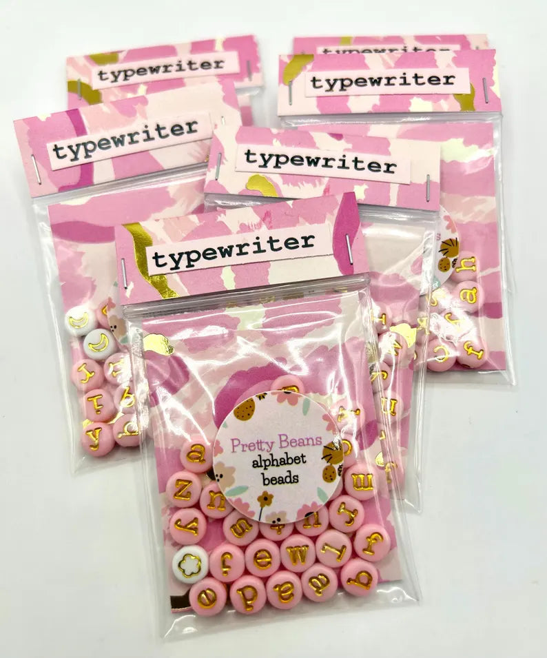 Lowercase gold alphabet beads featuring 7mm typewriter font, ideal for jewelry making and craft projects.