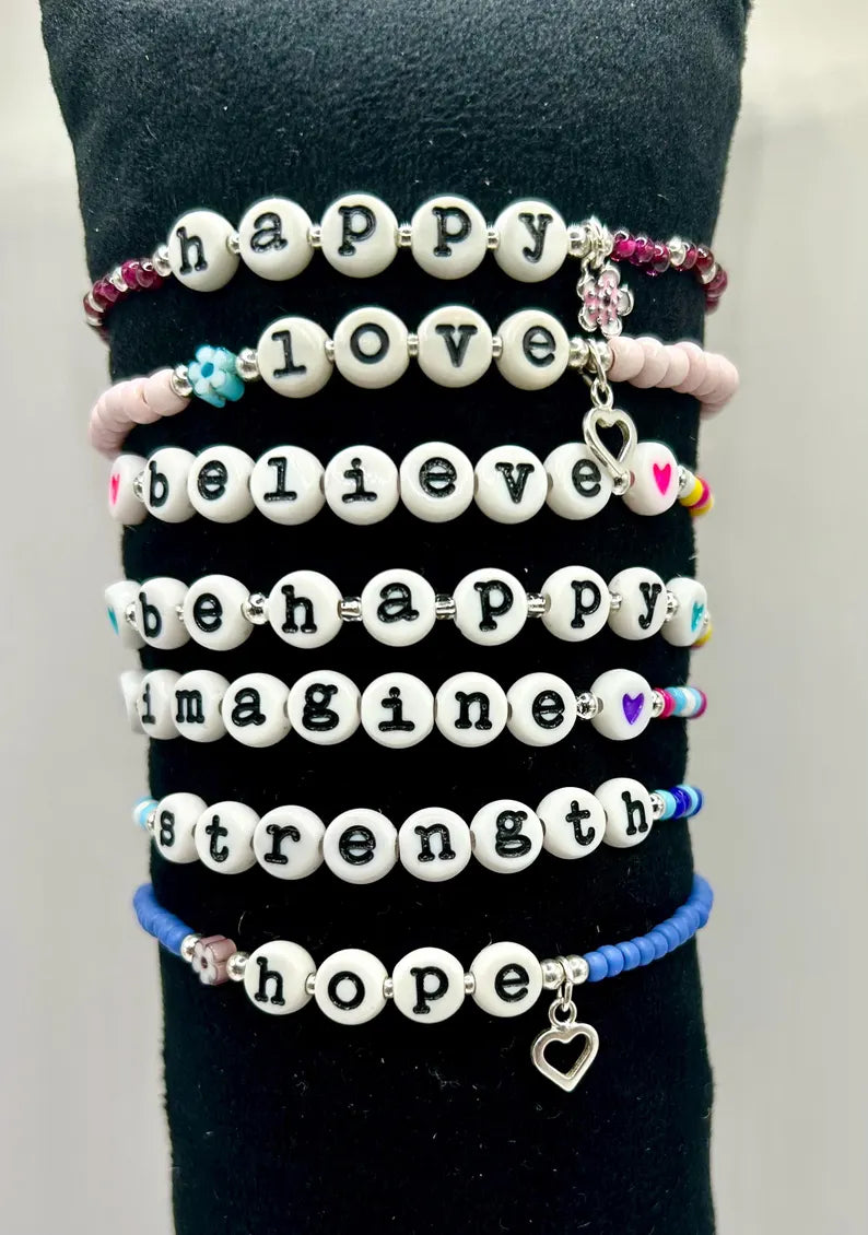DIY jewelry kit by Pretty Beans with seed beads, letter charms, and silver charms for making mini bracelets.