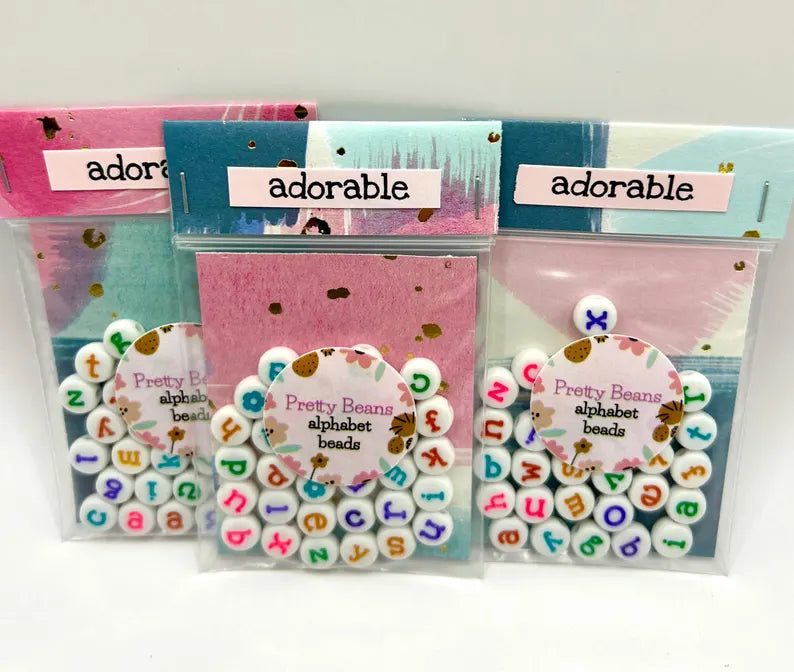 Colorful lowercase alphabet beads with 7mm size, perfect for jewelry making by Pretty Beans, shown in a close-up image.