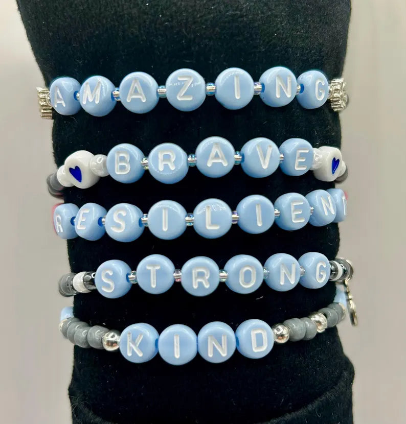 DIY Pretty Beans bracelet making kit with seed beads, letter charms, and silver charms for creating custom jewelry.