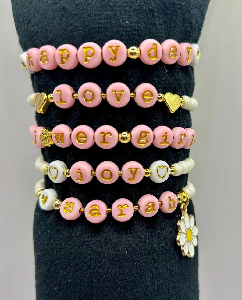 DIY jewelry kit by Pretty Beans featuring seed beads, letter charms, and silver charms for making mini bracelets.